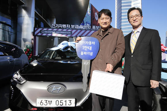 1만 번째 전기차 구매자 남궁윤 씨(왼쪽)가 현대차 '아이오닉 일렉트릭'을 전달받고, 현대차 국내영업본부장 이광국 부사장과 기념 촬영을 하고 있다. (사진=현대자동차)