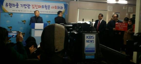 6일 오전 춘천시민연대가 춘천시청 열린공간에서 마련한 기자회견에 김진태 국회의원후원회장 등이 난입해 소동을 빚었다. (사진 오른쪽)이 피켓을 들고 항의하는 모습. (사진=춘천시민연대)