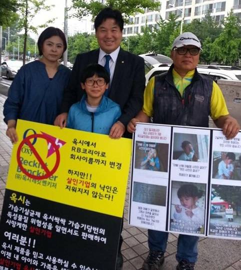 더불어민주당 홍의락 국회의원(사진 중앙)이 옥시 가습기살균제의 부당함을 알리기 위해 피켓시위하는 시민들과 사진 촬영하는 모습. (사진=홍의락 국회의원 페이스북)