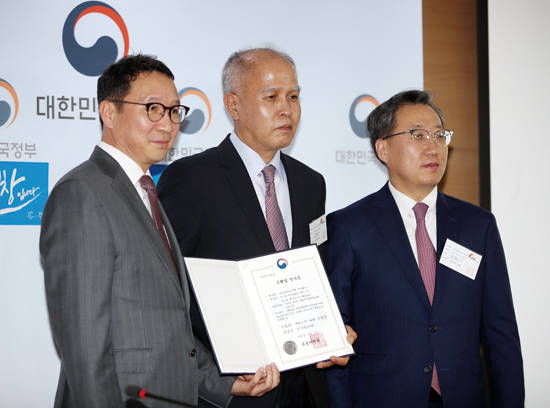 4월 5일 서울 세종로 정부종합청사에서 김학수 금융위원회 금융서비스국장(왼쪽)이 카카오뱅크 이용우(가운데)·윤호영(오른쪽) 공동대표에게 은행업 인가증을 주고 기념촬영을 하고 있다. 사진 = 연합뉴스