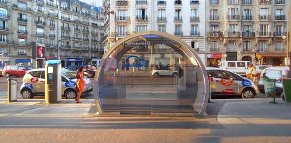 파리 시내 디데로가(Boulevard Diderot)에 마련된 '오토리브(Autolib')' 대여 스테이션. 무인 대여 시스템인 키오스크와 충전기가 보이고, 옆에 두 대의 '블루카'가 주차되어 있다. (사진 = Poulpy, 위키피디아)