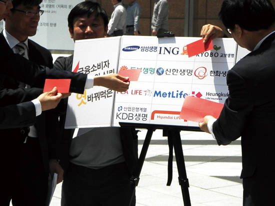 지난 2016년 시민사회단체가 생명보험사들의 자살보험금 지급을 촉구하며 레드카드를 붙이는 모습. 사진 = 이성호 기자
