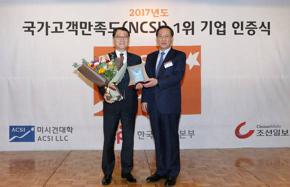 12월 5일 오전 소공동 롯데호텔에서 진행된 한국생산성본부 주관 2017 국가고객만족도(NCSI) 1위 기업 인증식에서 신한은행 위성호 은행장(왼쪽)이 한국생산성본부 홍순직 회장으로부터 상패와 꽃다발을 받고 기념촬영을 하고 있다. (사진 = 신한은행)
