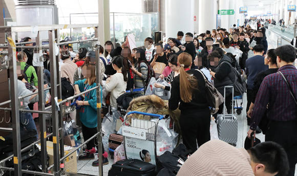 지난 12월 22일 인천공항 탑승동 면세품 인도장이 중국인 여행객들로 크게 붐비고 있다. 사진 = 연합뉴스