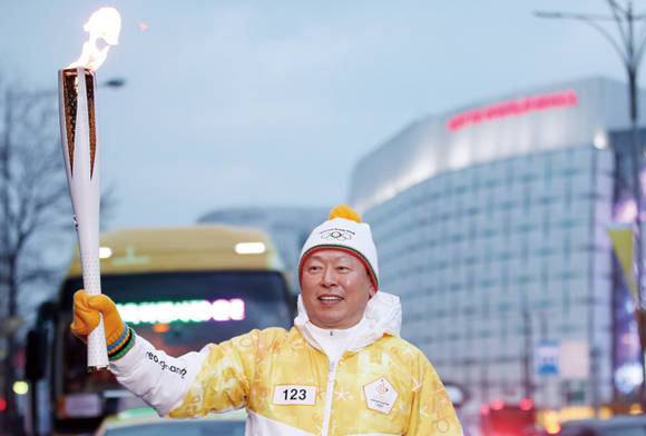 신동빈 롯데그룹 회장이 1월 14일 서울 송파구 롯데월드타워 일원에서 평창동계올림픽 성화봉송을 하고 있다. 사진 = 연합뉴스